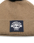 Cappello marrone con pompon blu e patch logo Timberland